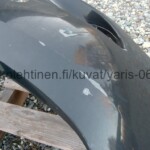 Toyota Yaris 2006 - 2008 tumman harmaa etupuskuri, naarmuja oikeassa päädyssä ajovalon paikan ja sumuvalon paikan välissä.